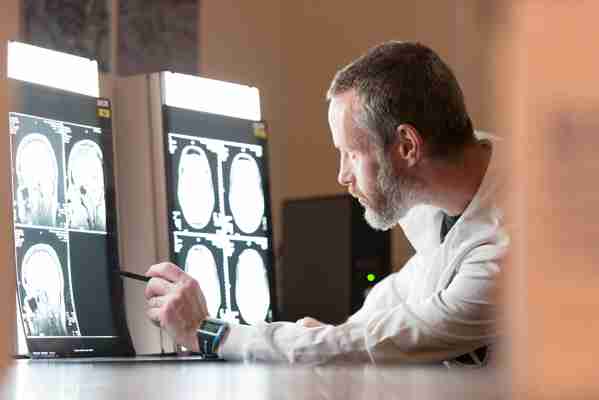ientist looking at brain scans